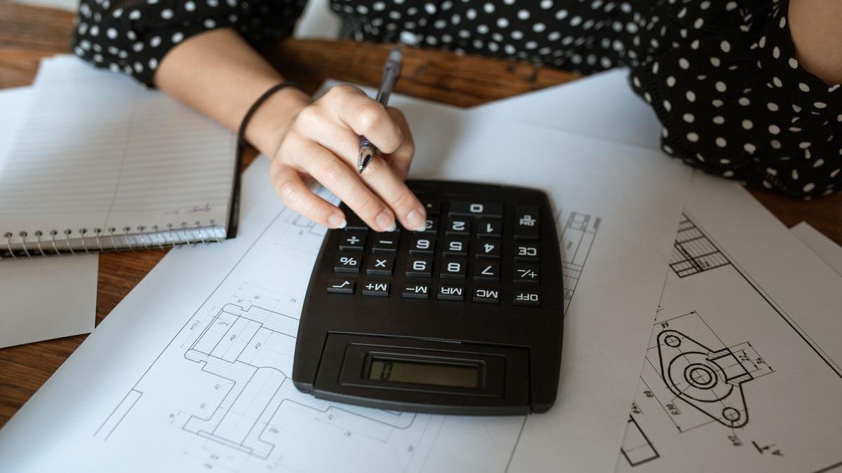Calculadora sobre um desenho técnico de arquitetura, em uma mesa de trabalho