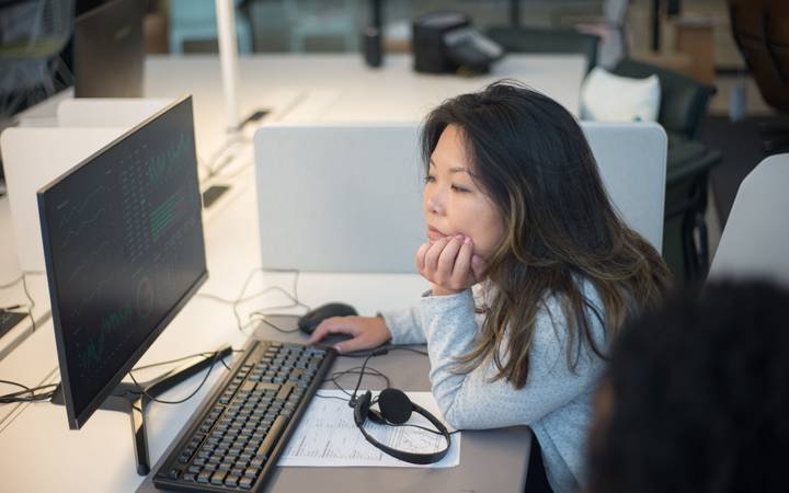 Pessoa examinando informações na tela de um computador