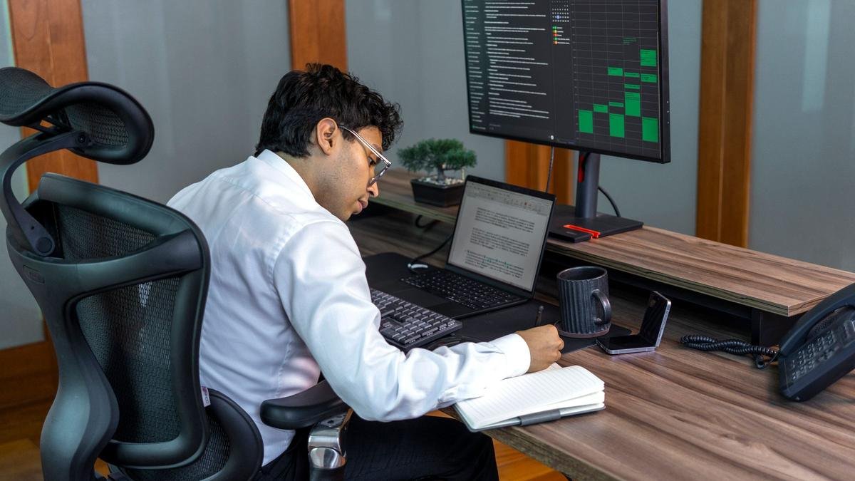 Profissional analisando dados em uma tela de computador, em escritório