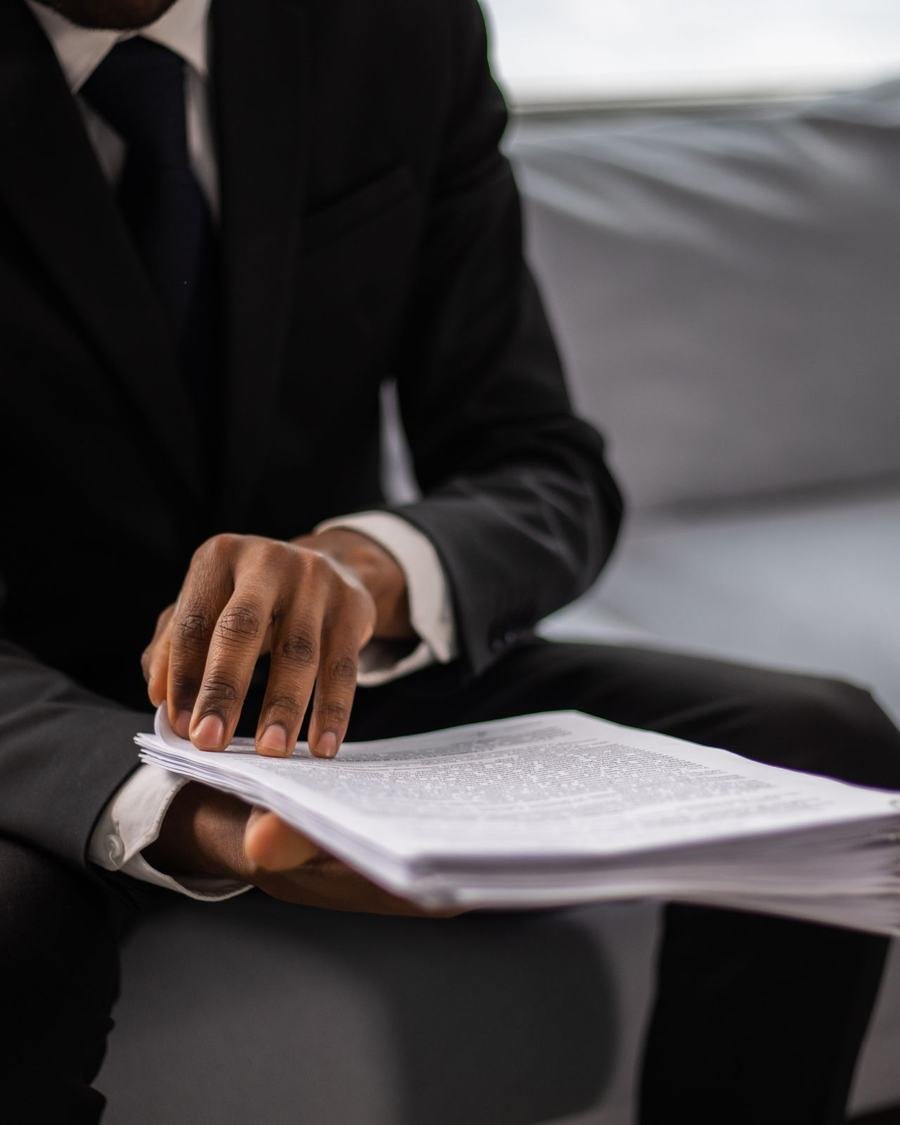 Profissional de terno examinando um conjunto de documentos
